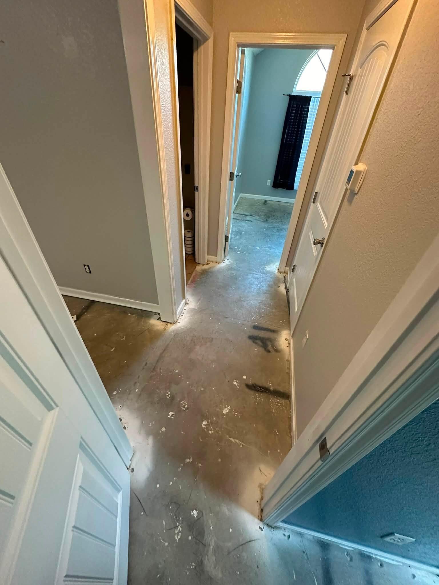 Hallway stripped down to the concrete slab after damaged flooring was removed