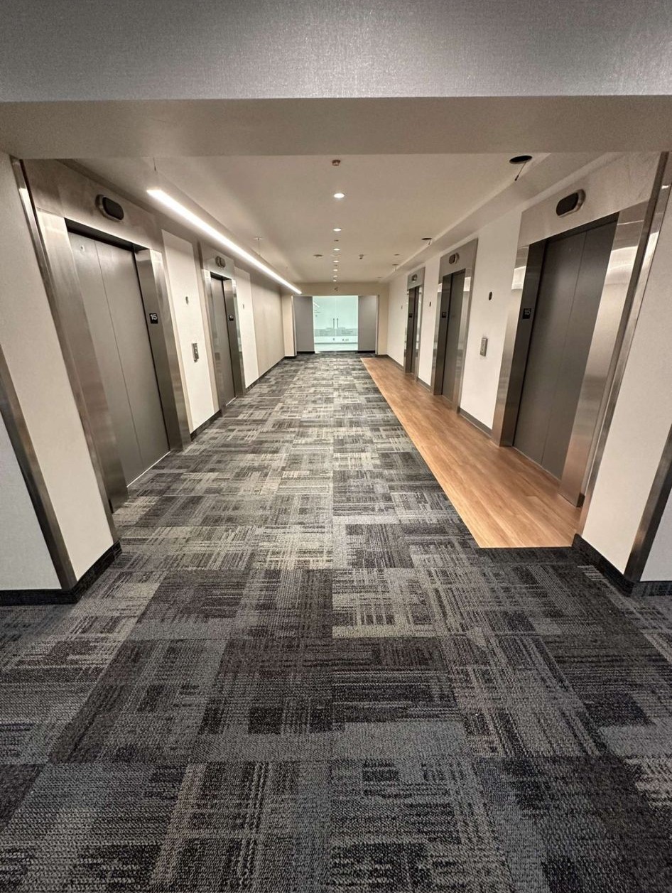 Commercial high-rise elevator lobby carpet tile flooring with hardwood transition strips Toronto